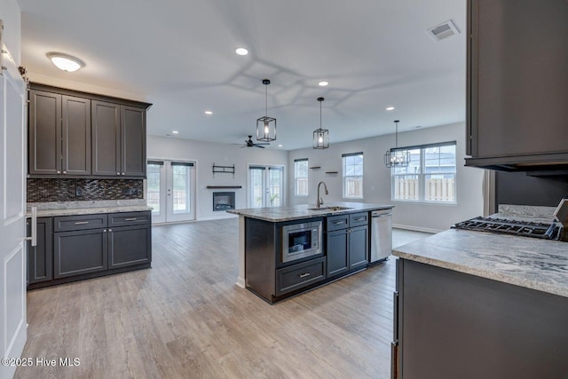 7053 Trailhead Rd, Leland, NC 28451 - kitchen with appliances with stainless steel finishes, healthy amount of natural light, a sink, recessed lighting, and light wood-style flooring