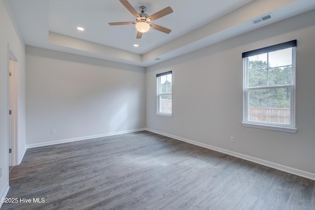 7053 Trailhead Rd, Leland, NC 28451 - empty room with a tray ceiling, dark wood-style flooring, a ceiling fan, baseboards, and recessed lighting