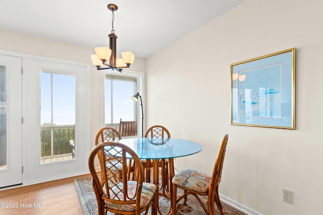 dining room with a chandelier, baseboards, and wood finished floors