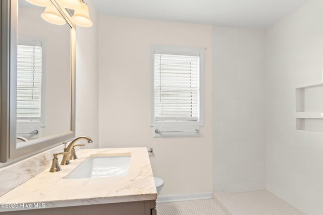 full bathroom with tiled shower, baseboards, toilet, and vanity