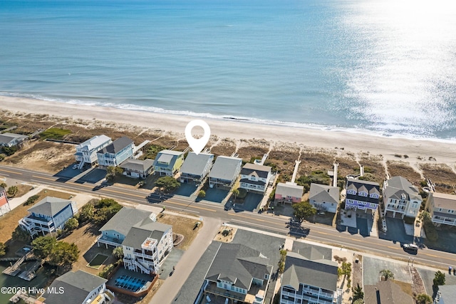 drone / aerial view with a residential view, a view of the beach, and a water view