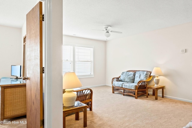 sitting room with a ceiling fan, carpet, baseboards, and a textured ceiling