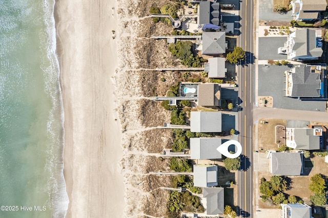 birds eye view of property with a water view and a view of the beach