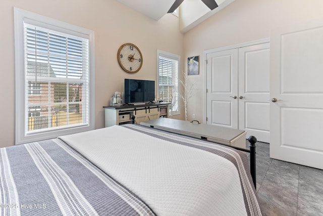 bedroom featuring a closet, light tile patterned floors, ceiling fan, and vaulted ceiling