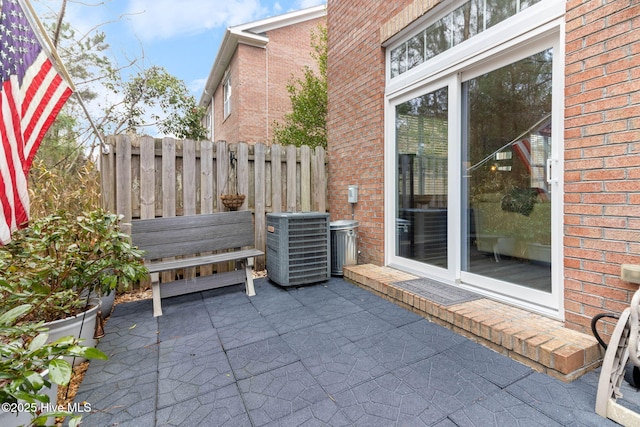 view of patio with central air condition unit and fence