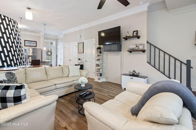 living room with ceiling fan, stairway, wood finished floors, and crown molding