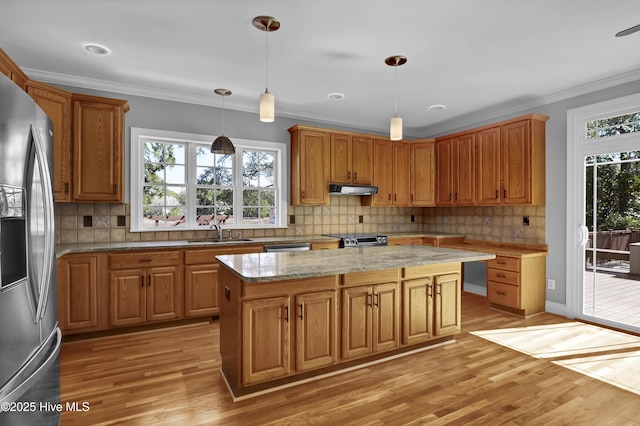 kitchen featuring a sink, stainless steel fridge, light wood finished floors, and ornamental molding