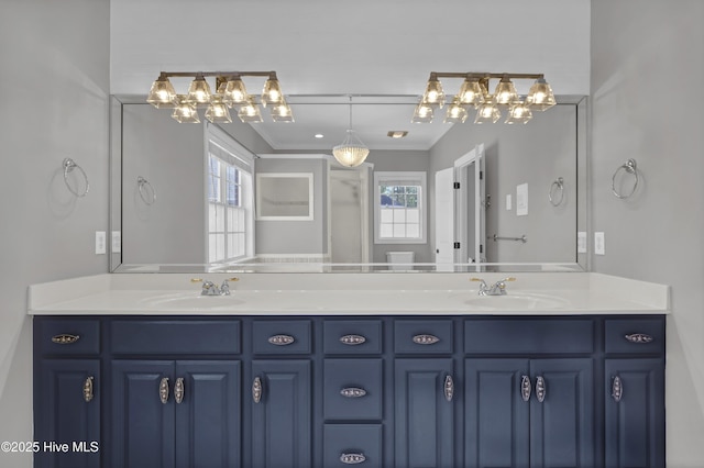 full bathroom featuring double vanity, crown molding, and a sink