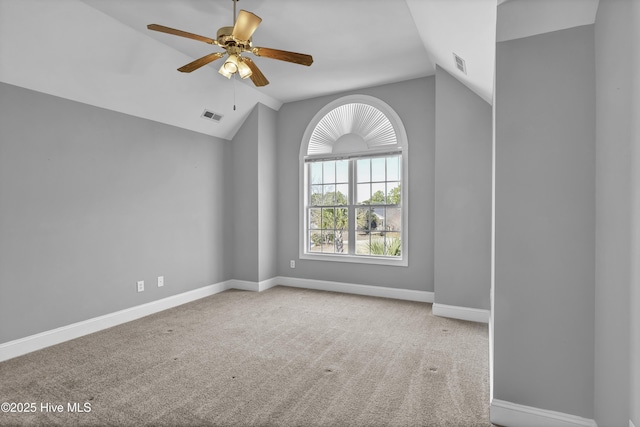 unfurnished room featuring lofted ceiling, carpet, visible vents, and baseboards