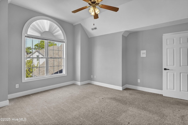 spare room featuring visible vents, baseboards, ceiling fan, lofted ceiling, and carpet flooring