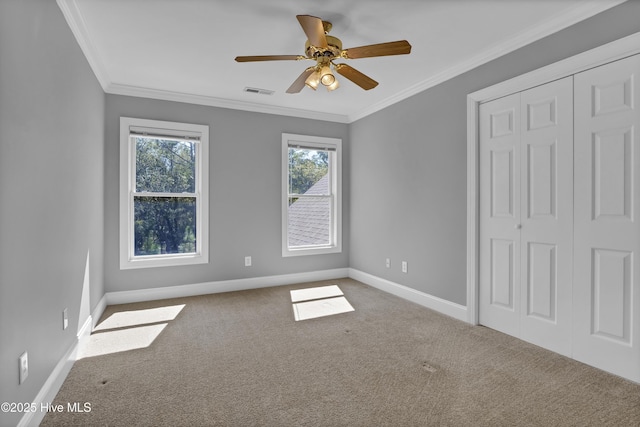 unfurnished bedroom featuring a closet, visible vents, carpet flooring, and crown molding