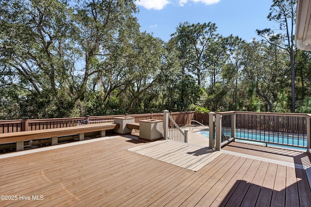 wooden deck featuring an outdoor pool and fence