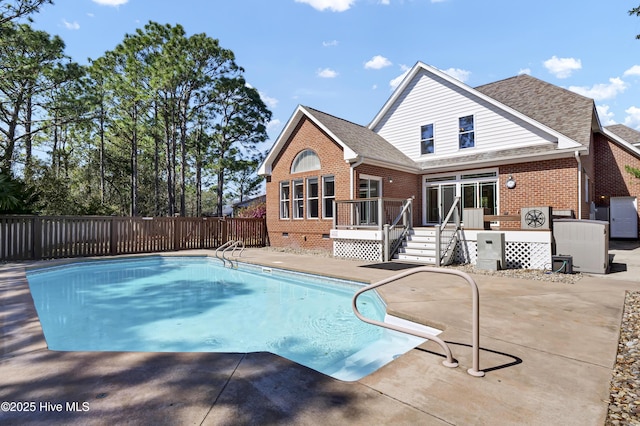 view of swimming pool featuring a wooden deck, a patio, a fenced in pool, and fence