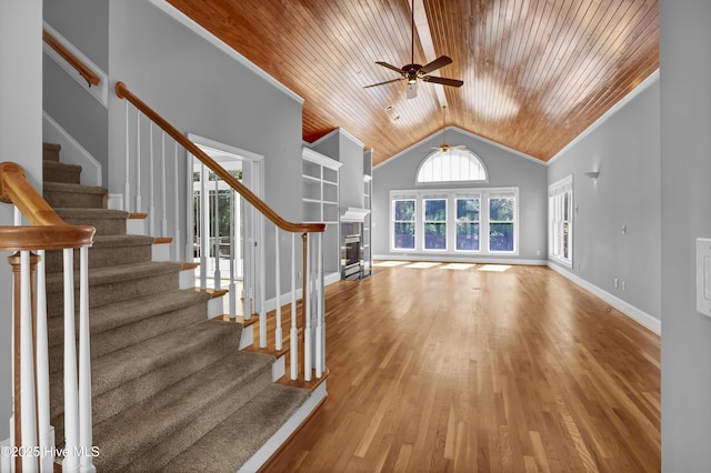 unfurnished living room featuring wood finished floors, baseboards, stairs, vaulted ceiling, and wooden ceiling