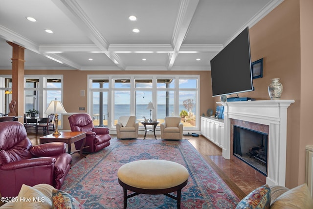 living area featuring beam ceiling, coffered ceiling, crown molding, and a premium fireplace