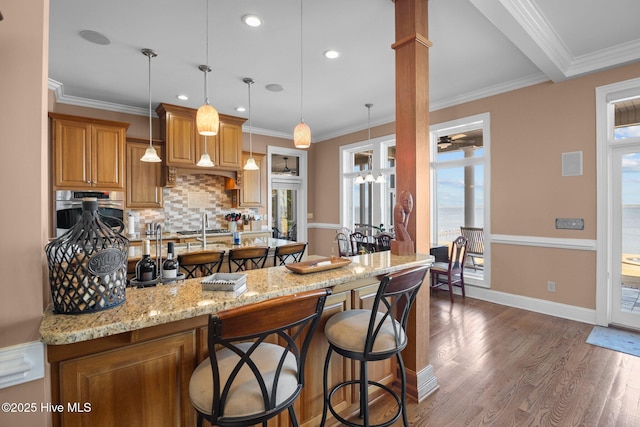 kitchen with oven, light stone countertops, dark wood finished floors, a breakfast bar, and decorative backsplash