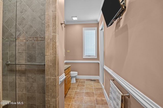 full bathroom featuring tile patterned floors, toilet, a tile shower, crown molding, and vanity