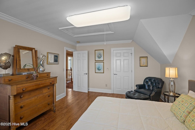 bedroom with dark wood-style floors, attic access, crown molding, and baseboards