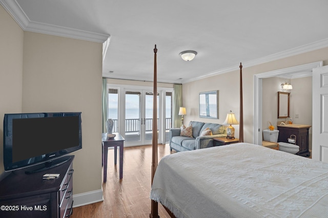 bedroom with baseboards, wood finished floors, crown molding, and access to outside