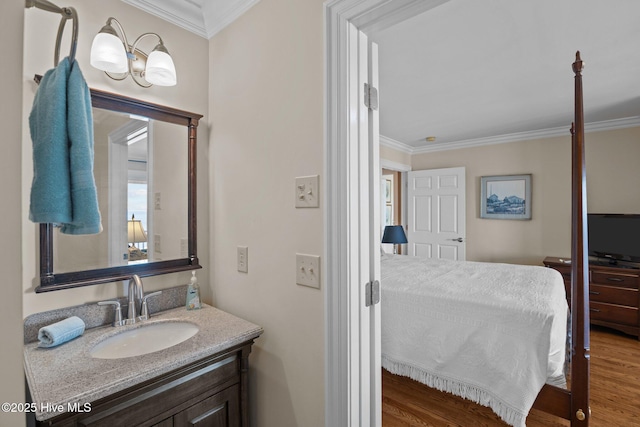 bathroom featuring wood finished floors, ornamental molding, and vanity