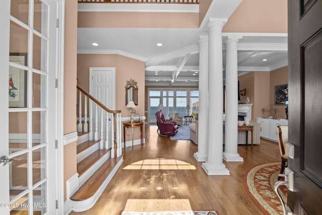 entryway featuring coffered ceiling, ornate columns, and wood finished floors