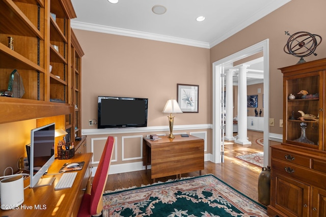 office area featuring wood finished floors, crown molding, and decorative columns