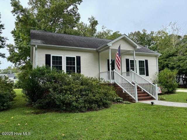 view of front of home featuring a front yard and a shingled roof