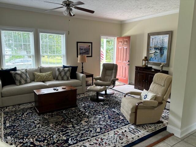 tiled living area with ceiling fan, crown molding, baseboards, and a textured ceiling