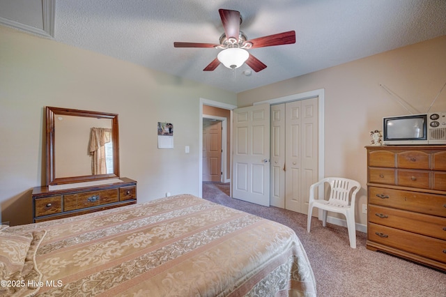 carpeted bedroom featuring a closet, baseboards, a textured ceiling, and ceiling fan