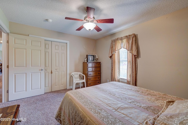 bedroom featuring a closet, carpet, a ceiling fan, and a textured ceiling