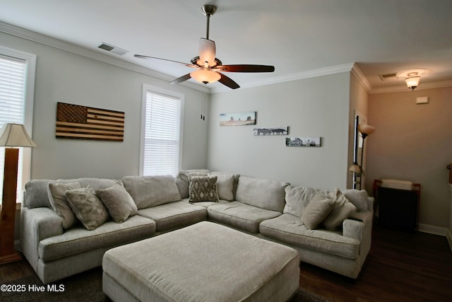 living area with a wealth of natural light, visible vents, and dark wood-type flooring