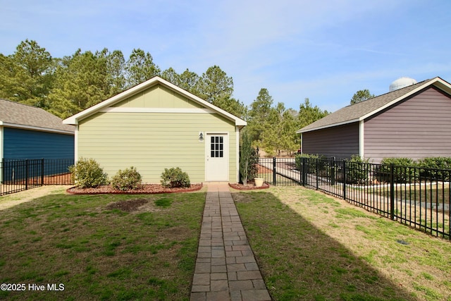 back of property with a yard, an outbuilding, board and batten siding, and fence