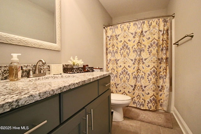 bathroom featuring vanity, tile patterned floors, toilet, and baseboards