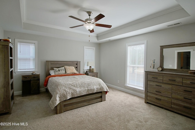 bedroom with visible vents, light carpet, ornamental molding, a tray ceiling, and baseboards