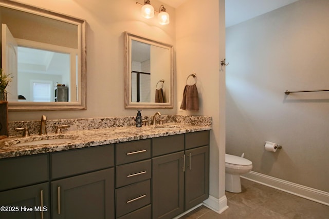 full bath featuring double vanity, toilet, baseboards, and a sink