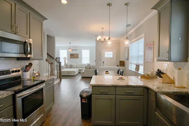 kitchen with tasteful backsplash, crown molding, appliances with stainless steel finishes, a peninsula, and dark wood-style flooring