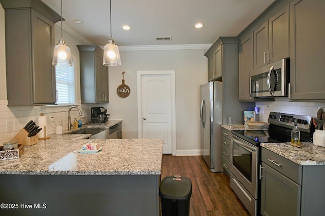 kitchen with light stone countertops, visible vents, ornamental molding, a sink, and appliances with stainless steel finishes