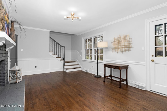 entryway with visible vents, crown molding, stairs, wood finished floors, and a notable chandelier