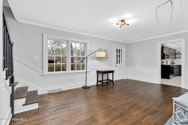 living room with visible vents, wood finished floors, ornamental molding, and stairway