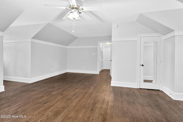 bonus room featuring dark wood finished floors, lofted ceiling, a ceiling fan, and baseboards