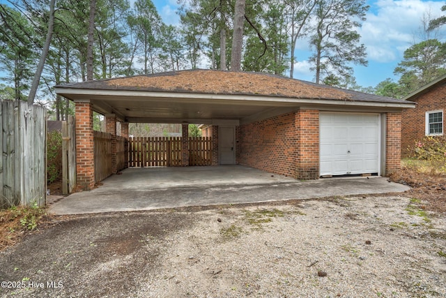 view of car parking featuring a carport, driveway, and fence