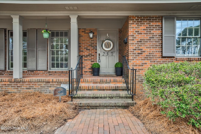 doorway to property featuring brick siding