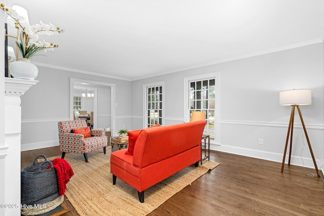 living room with crown molding, wood finished floors, and baseboards