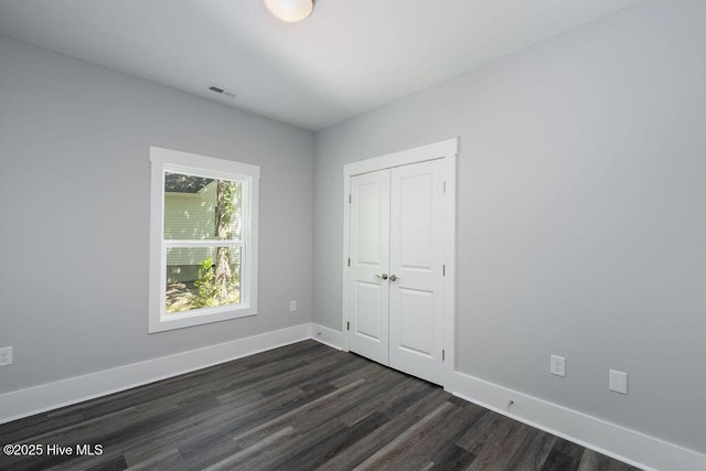 485 N Wild Rice Dr SW, Supply, NC 28462 - unfurnished bedroom with visible vents, dark wood-style flooring, baseboards, and a closet
