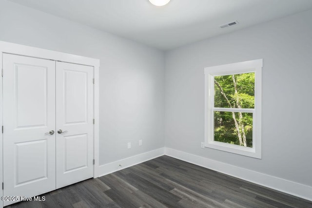 485 N Wild Rice Dr SW, Supply, NC 28462 - unfurnished bedroom with baseboards, visible vents, dark wood-style floors, and a closet