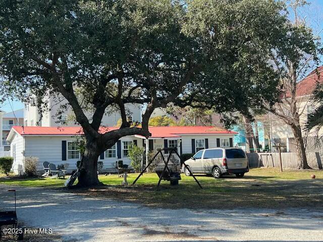 view of front facade with a front lawn and fence