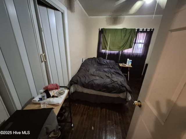 bedroom with wood finished floors and ornamental molding