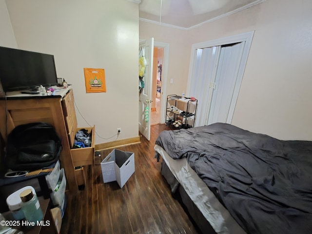 bedroom featuring ornamental molding, baseboards, and wood finished floors