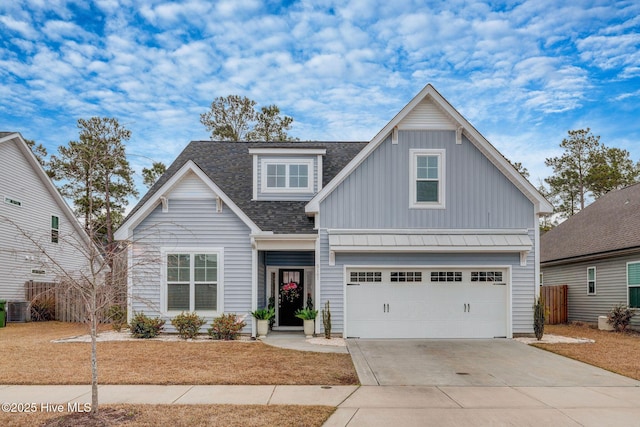 view of front of home featuring board and batten siding, a shingled roof, cooling unit, driveway, and an attached garage