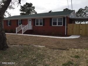 ranch-style house with fence